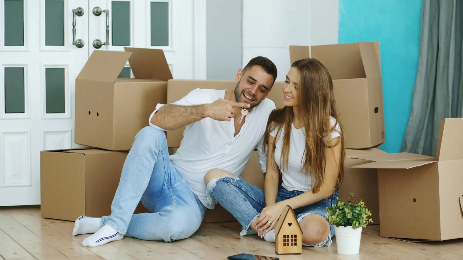 Couple souriant au milieu des cartons de son nouveau logement