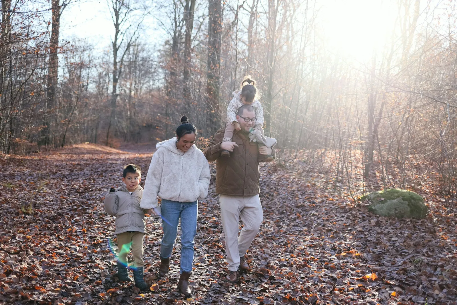 Famille en balade en forêt, dans la lumière du soir