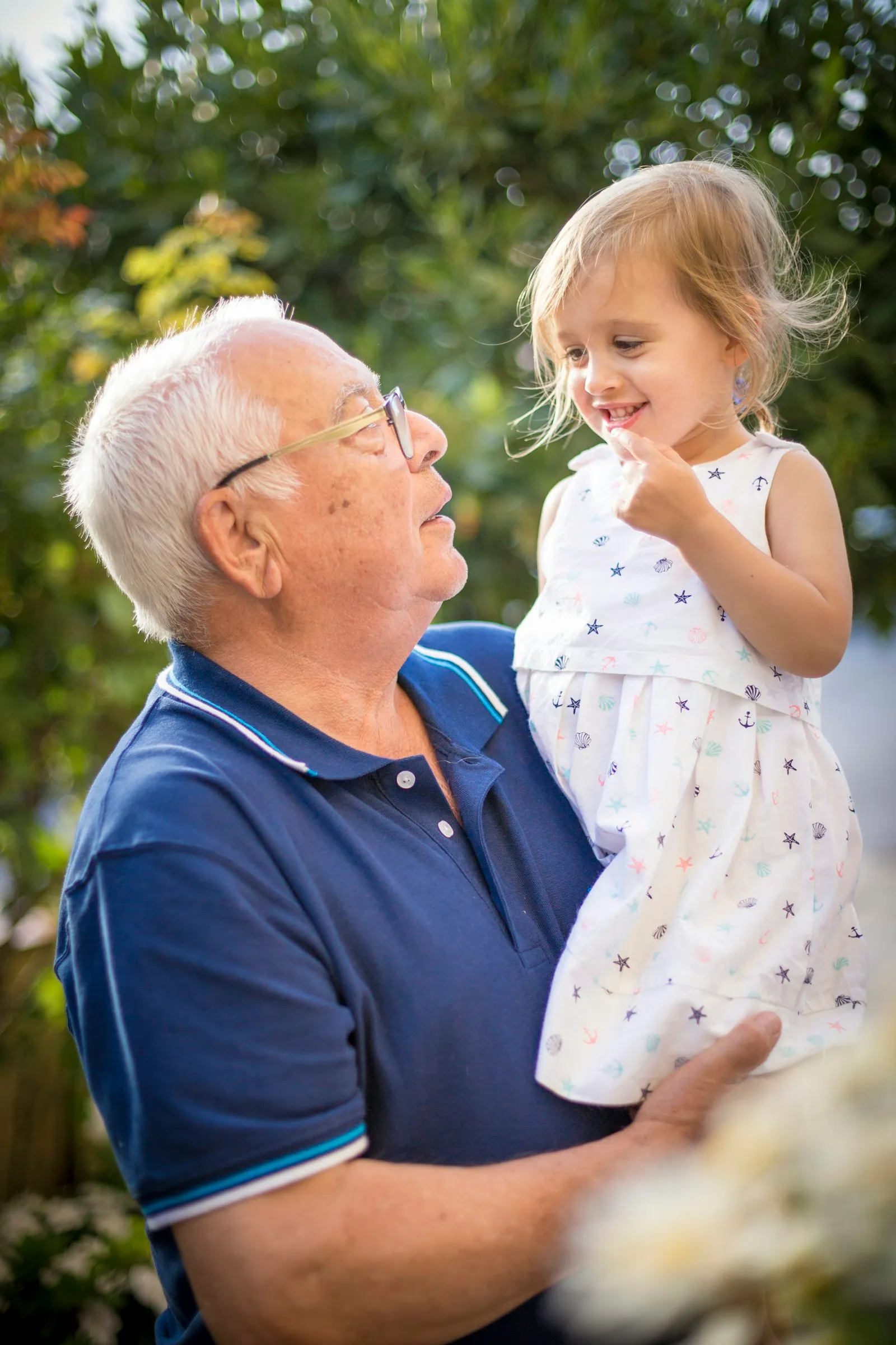 Grand-père et sa petite-fille riant dans le jardin